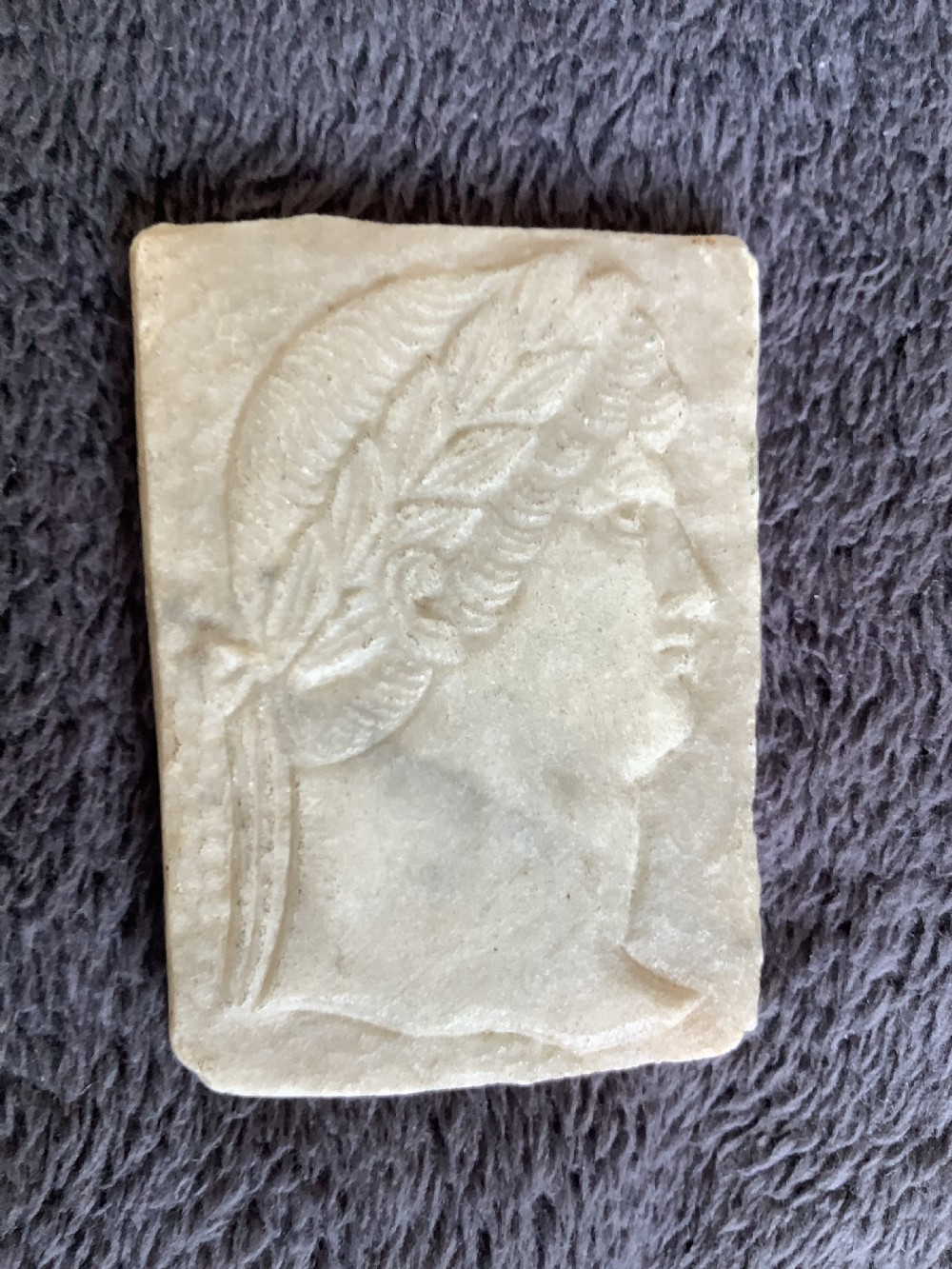A rectangular carved marble plaque depicting the profile portrait of a Roman Emperor wearing a laurel wreath. View II
