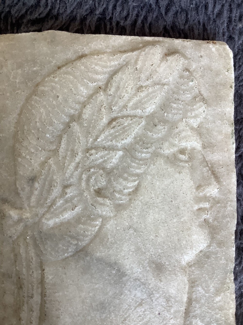 A rectangular carved marble plaque depicting the profile portrait of a Roman Emperor wearing a laurel wreath. View IV