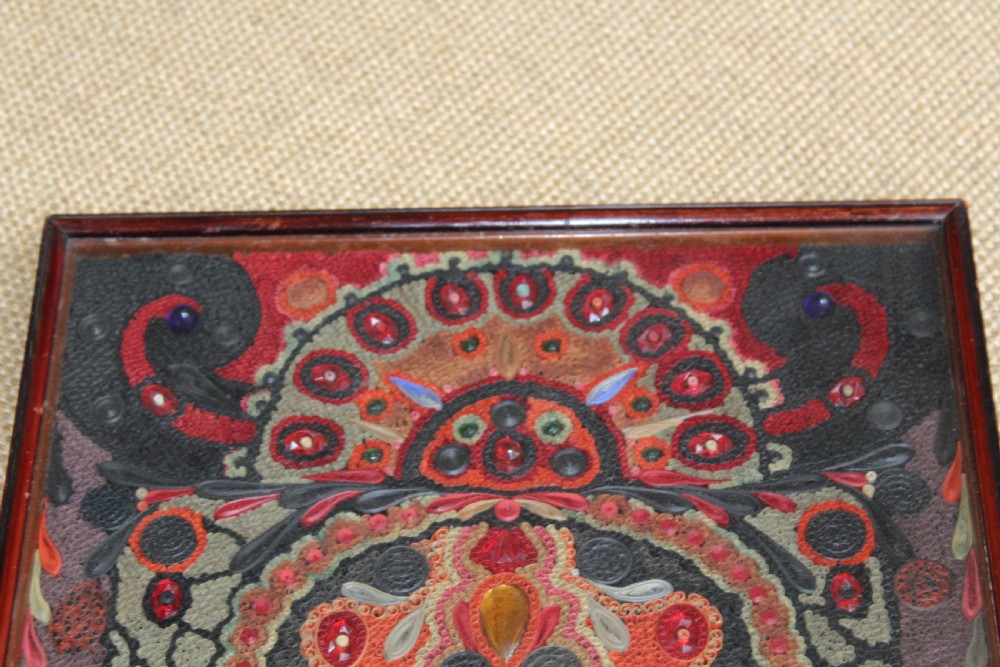 An antique framed 19th-century Indian quillwork picture featuring intricate red, black, and gold paper scrollwork embellished with beads and small painted portrait miniatures. View III