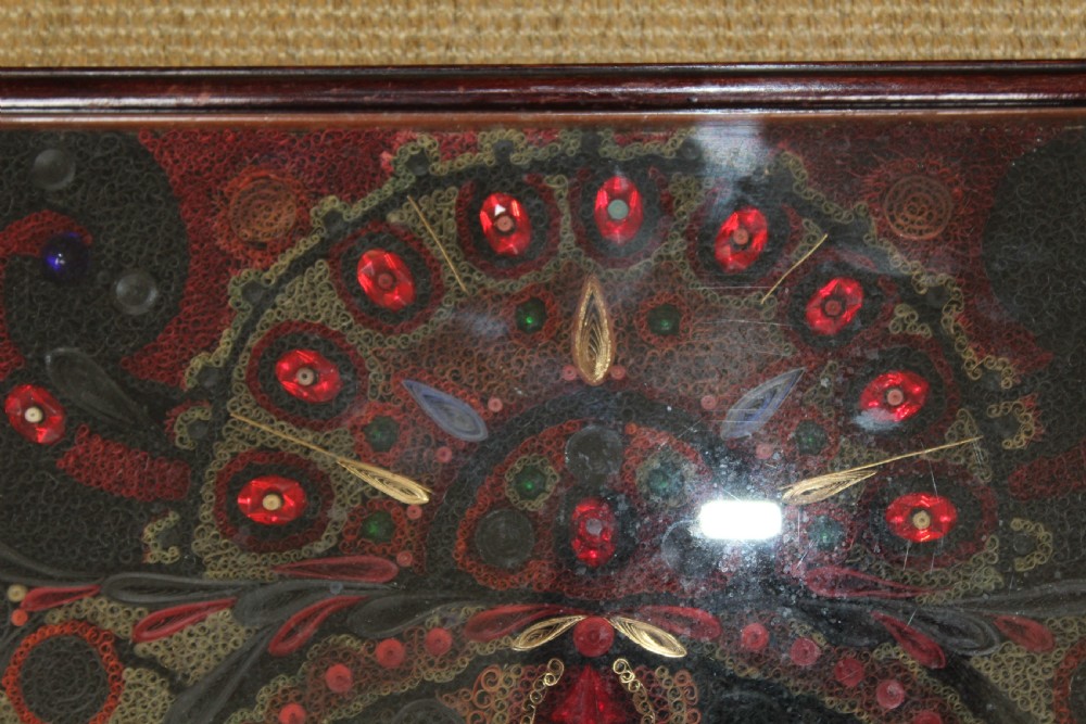 An antique framed 19th-century Indian quillwork picture featuring intricate red, black, and gold paper scrollwork embellished with beads and small painted portrait miniatures. View V