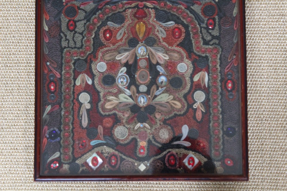 An antique framed 19th-century Indian quillwork picture featuring intricate red, black, and gold paper scrollwork embellished with beads and small painted portrait miniatures. View VI