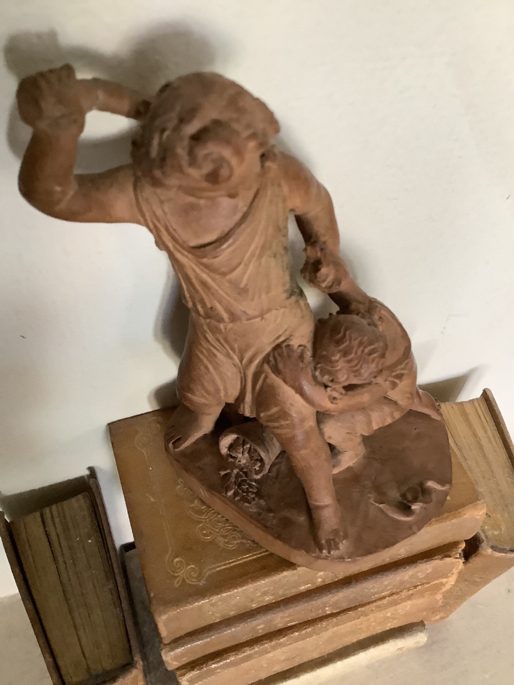 A 19th-century terracotta sculpture depicting two classical figures set on an integral oval base. View III