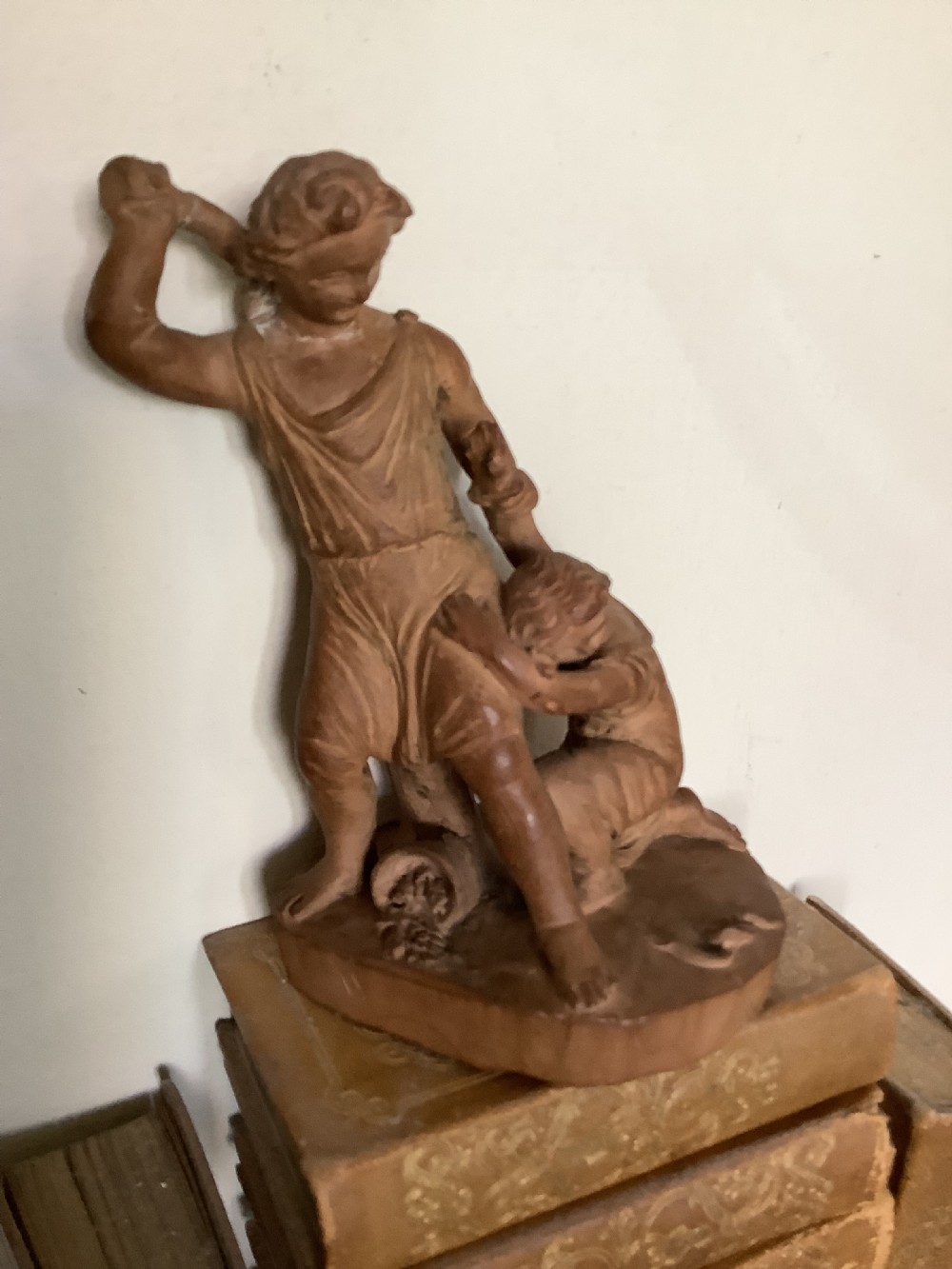 A 19th-century terracotta sculpture depicting two classical figures set on an integral oval base. View V
