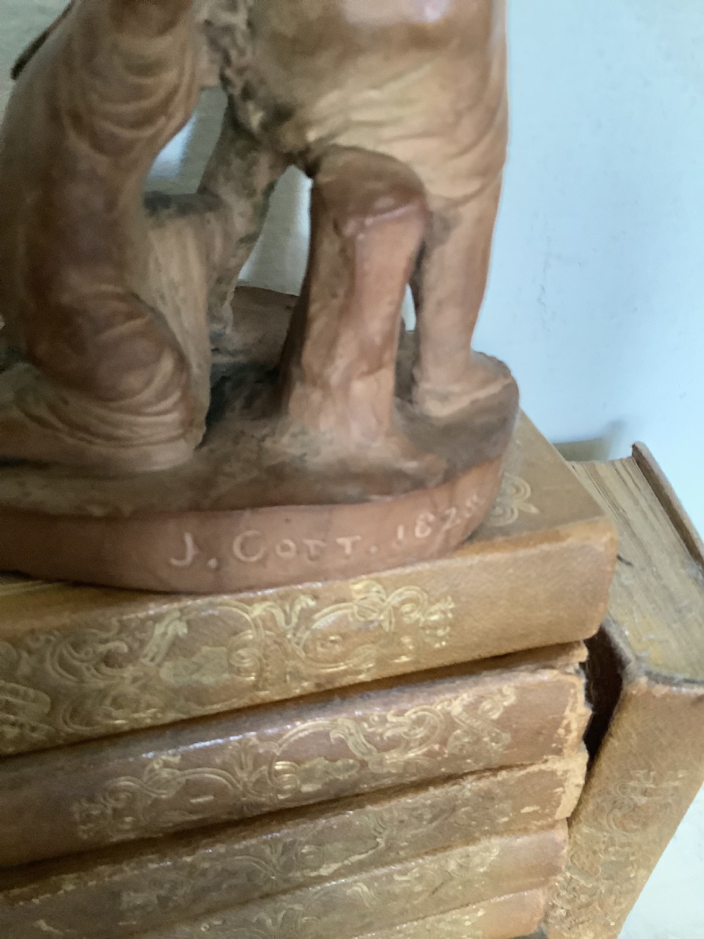 A 19th-century terracotta sculpture depicting two classical figures set on an integral oval base. View VI