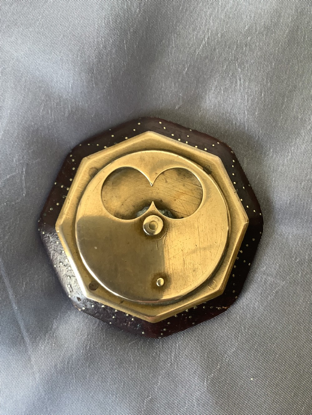An octagonal antique misers snuff box made from dark wood with brass pique inlay and a circular brass rotating mechanism. View VIII