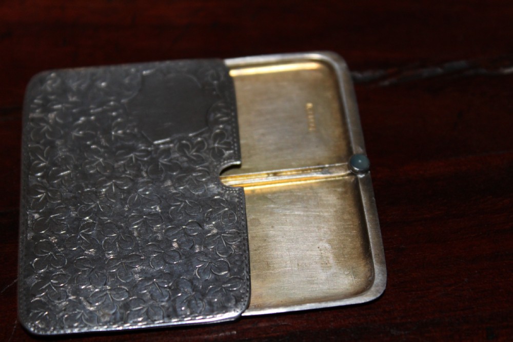 A small rectangular sterling silver stamp case featuring an engraved clover motif and a cabochon push clasp. View II