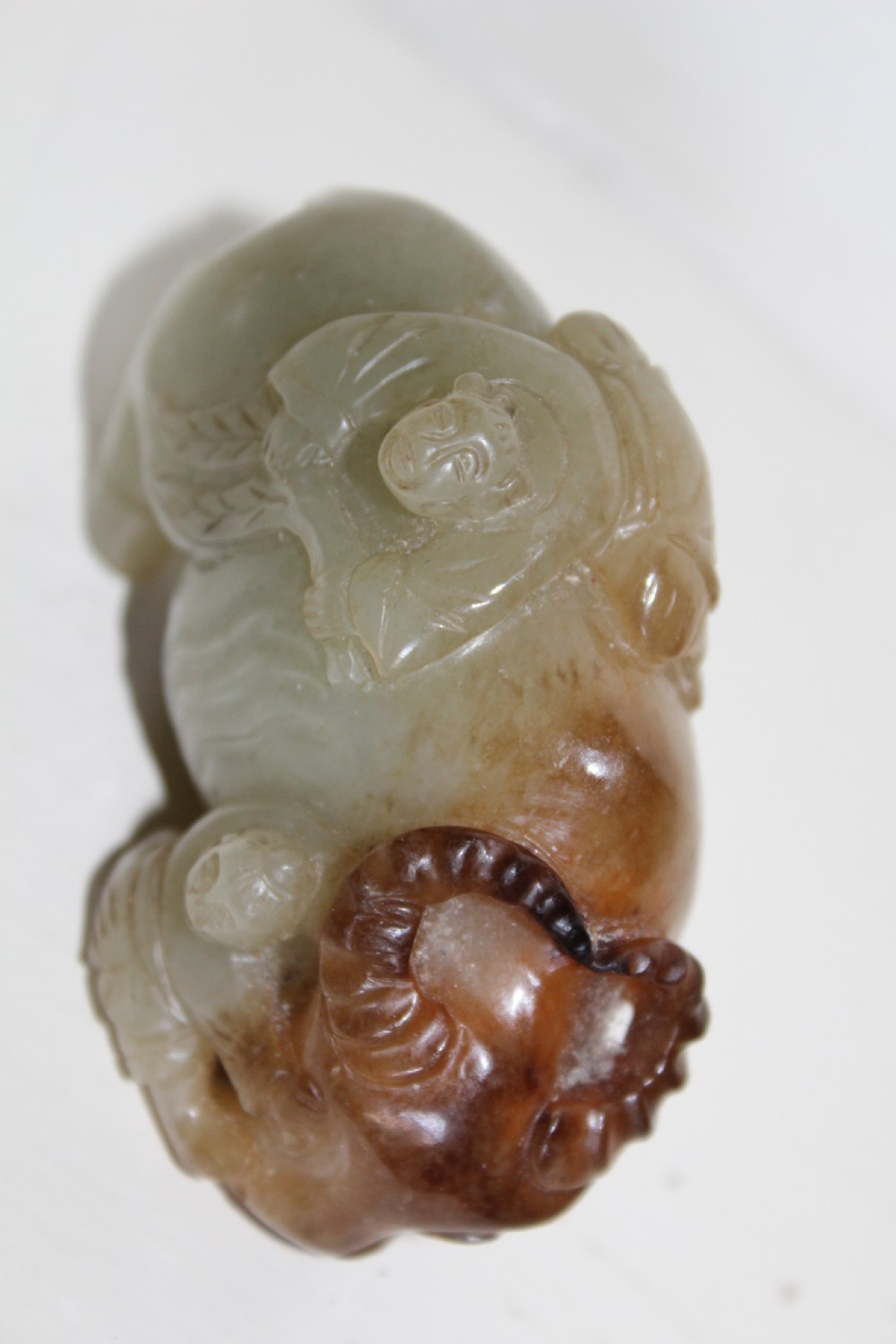 A finely carved pale green and russet jade buffalo  View II