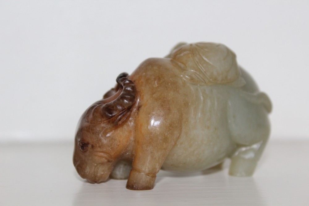 A finely carved pale green and russet jade buffalo  View IV