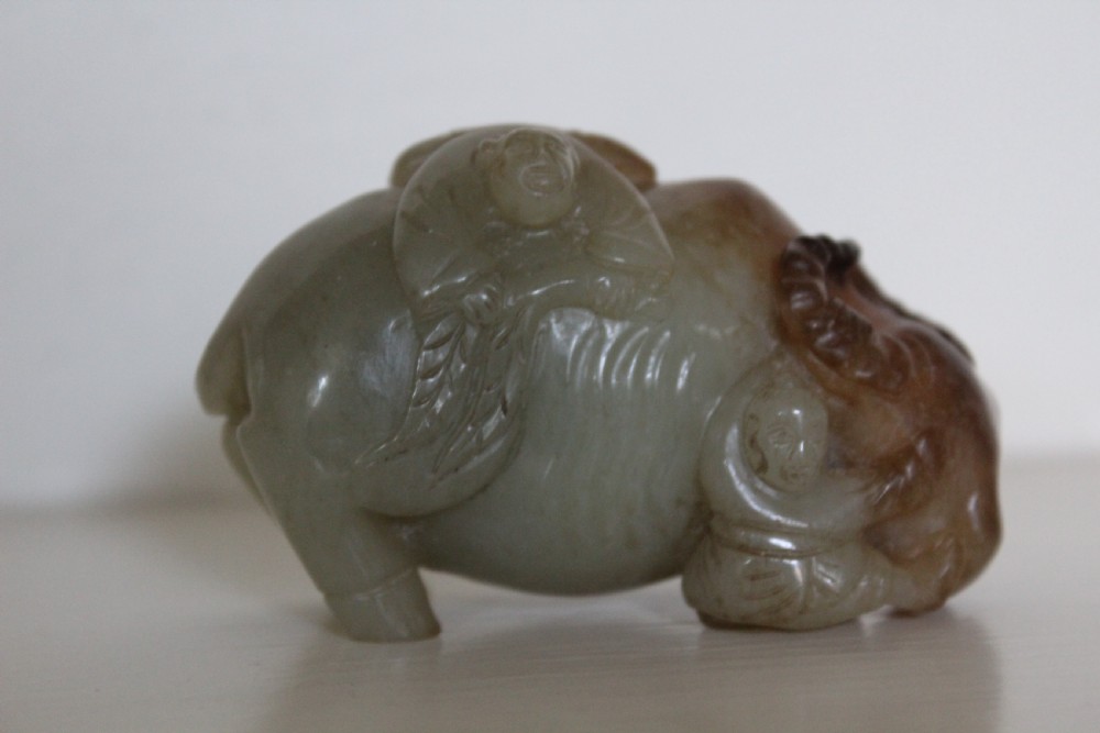 A finely carved pale green and russet jade buffalo  View V