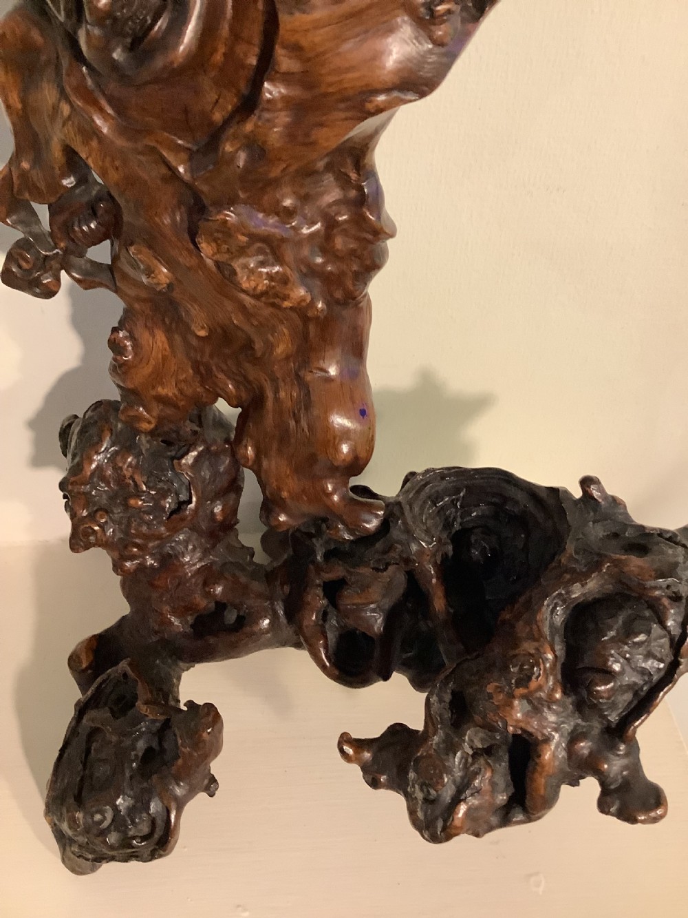 A carved dark brown rootwood sculpture depicting a smiling man carrying a child on his shoulders, integrated into the natural gnarled shape of the wood root. View IV