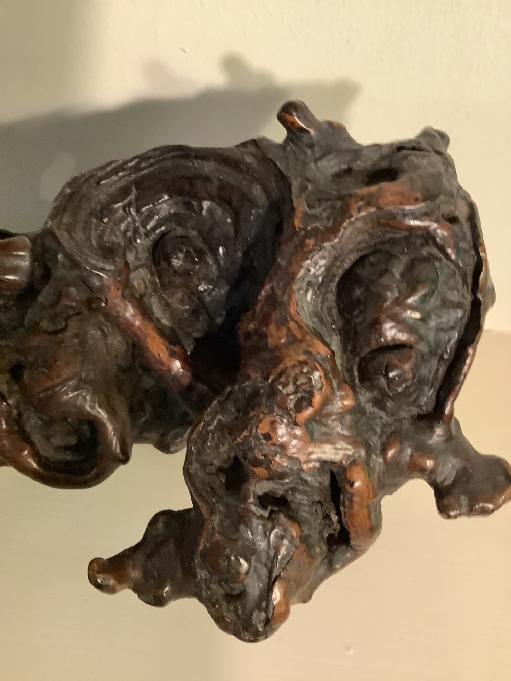 A carved dark brown rootwood sculpture depicting a smiling man carrying a child on his shoulders, integrated into the natural gnarled shape of the wood root. View VI