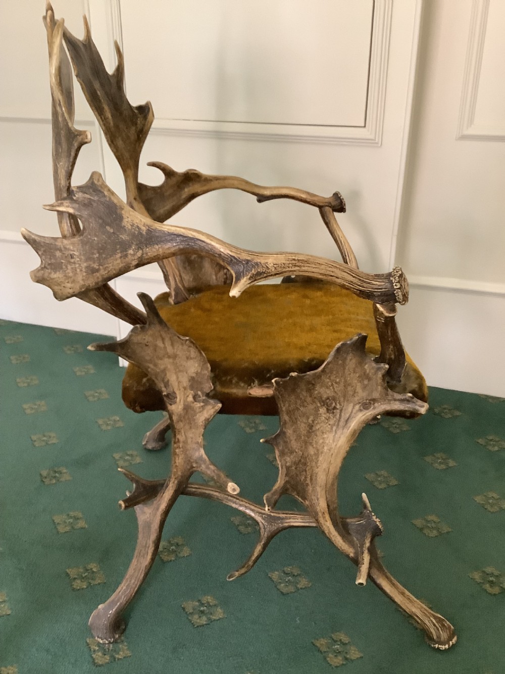 An antique Black Forest armchair constructed with interlocking natural deer antlers and a warm brown velvet upholstered seat. View VI