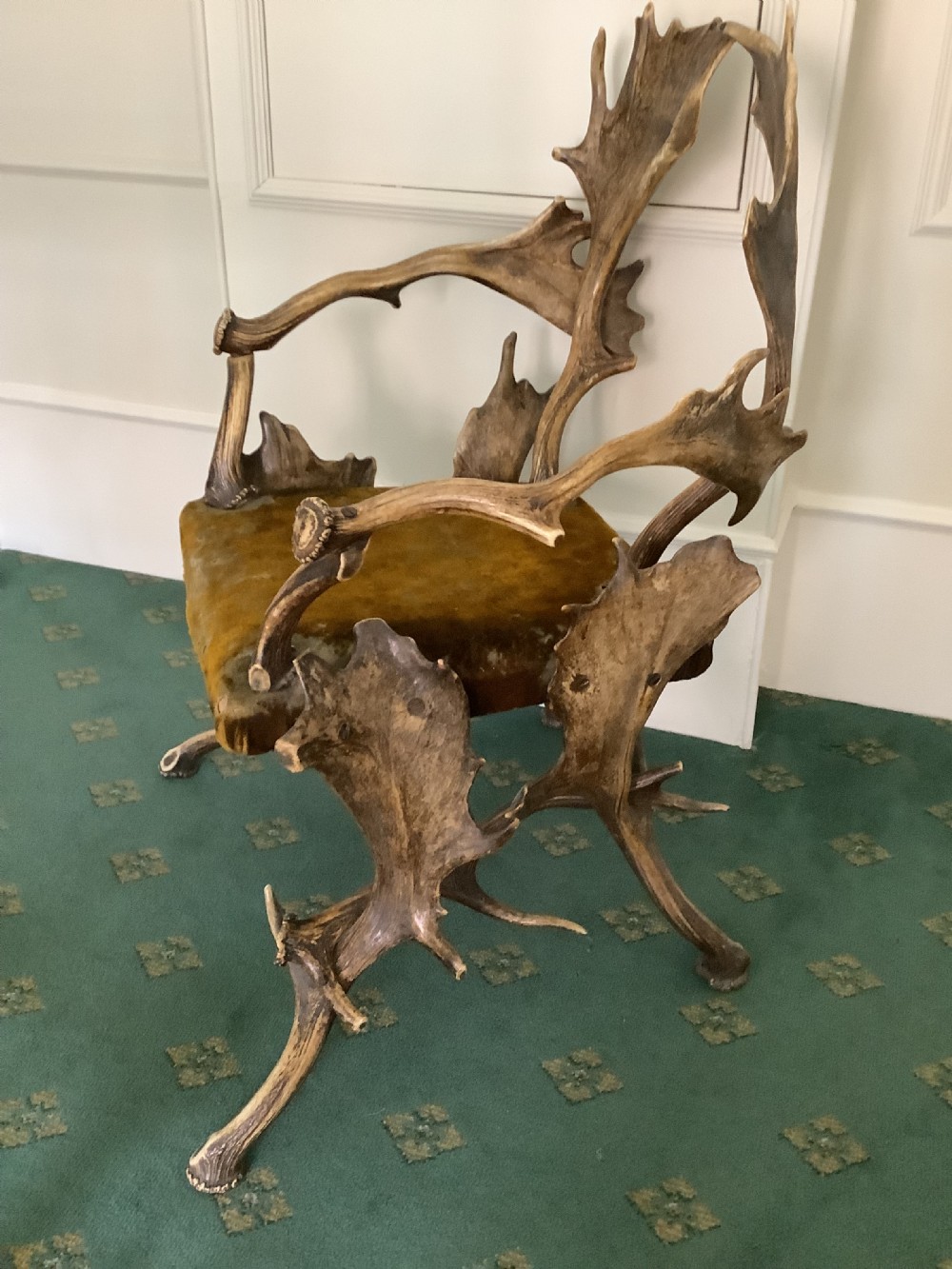 An antique Black Forest armchair constructed with interlocking natural deer antlers and a warm brown velvet upholstered seat. View II