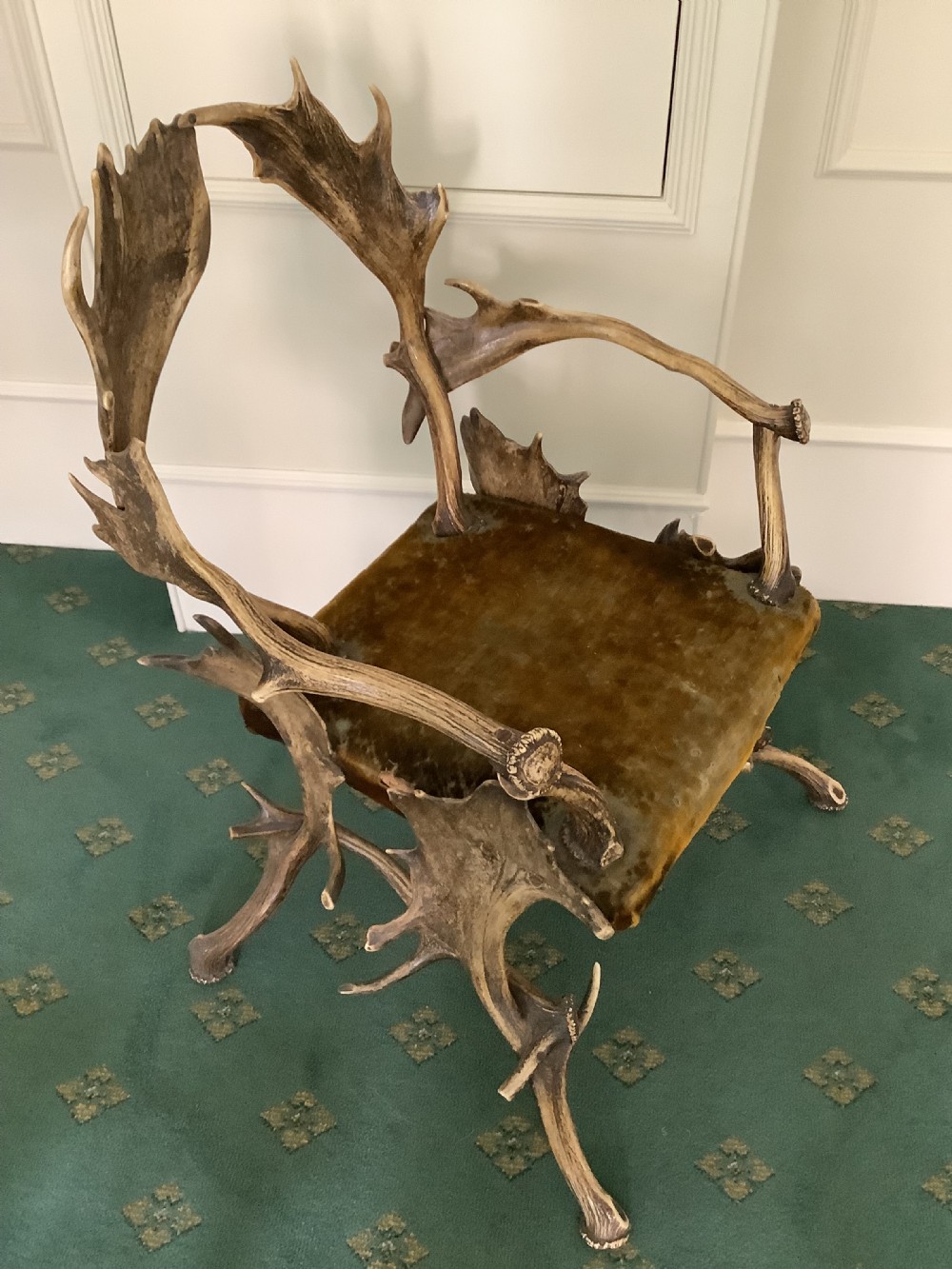 An antique Black Forest armchair constructed with interlocking natural deer antlers and a warm brown velvet upholstered seat. View IV