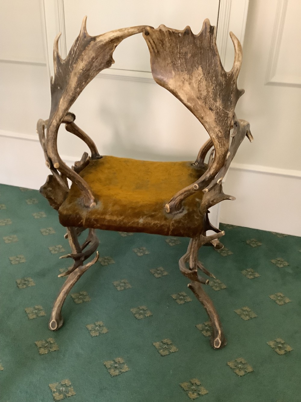 An antique Black Forest armchair constructed with interlocking natural deer antlers and a warm brown velvet upholstered seat. View VII
