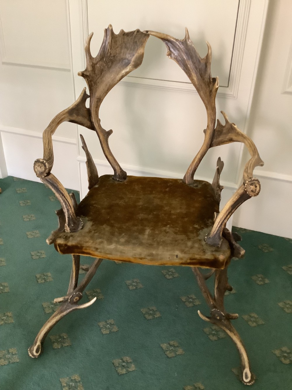 An antique Black Forest armchair constructed with interlocking natural deer antlers and a warm brown velvet upholstered seat. View VIII