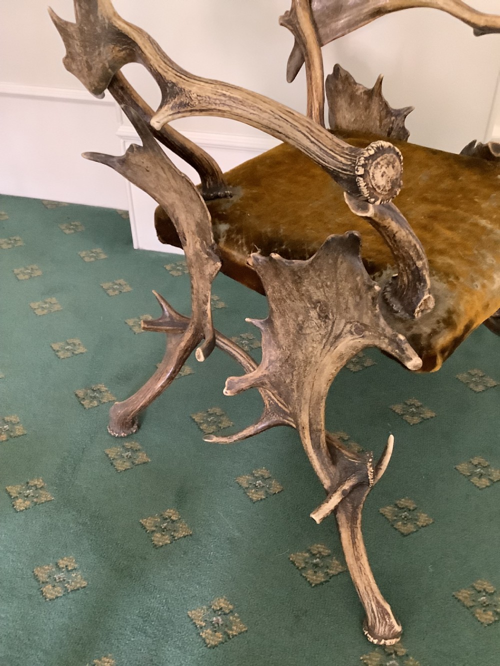 An antique Black Forest armchair constructed with interlocking natural deer antlers and a warm brown velvet upholstered seat. View IX
