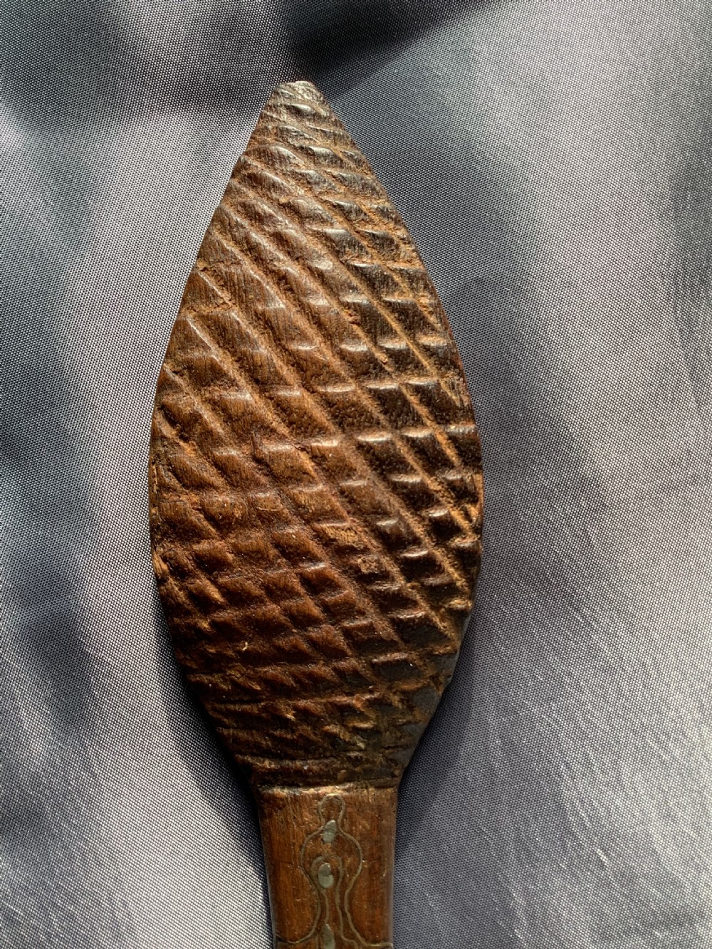 A carved dark wood back scratcher featuring a cross-hatched textured paddle head and delicate floral silver inlay along the slender handle. View VIII