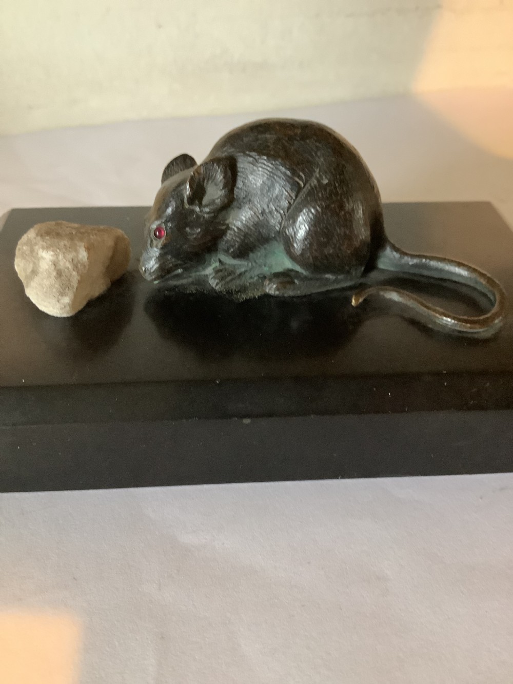 A delightful and charming bronze mouse paperweight on a black marble base 