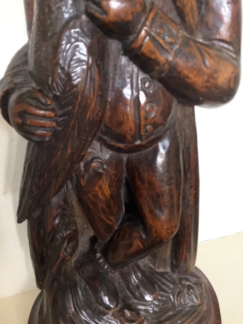 A pair of hand-carved dark wood candlesticks sculpted in the form of standing poachers holding game. View IV