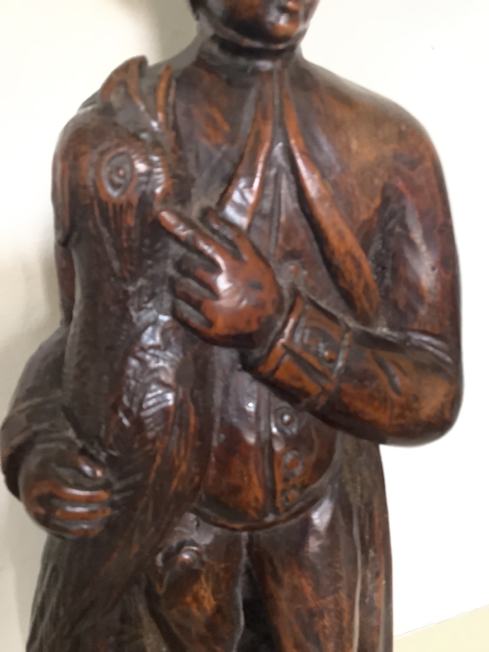 A pair of hand-carved dark wood candlesticks sculpted in the form of standing poachers holding game. View V