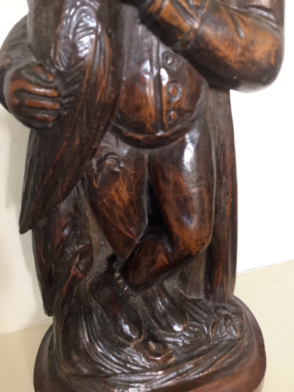 A pair of hand-carved dark wood candlesticks sculpted in the form of standing poachers holding game. View VII