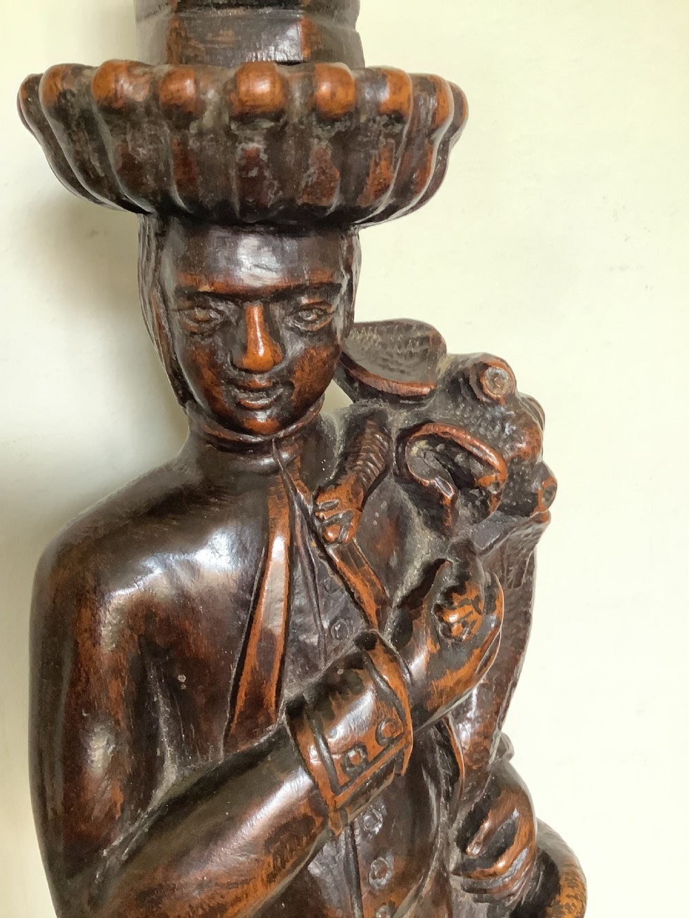 A pair of hand-carved dark wood candlesticks sculpted in the form of standing poachers holding game. View IX