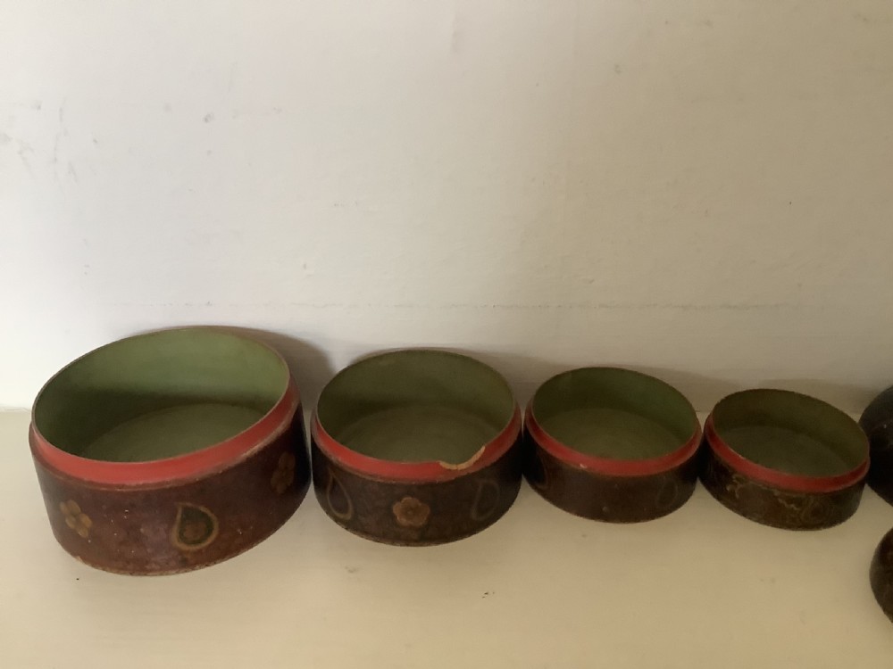 A set of four graduated round Kashmiri boxes painted in dark red and brown with gold floral and paisley motifs. View III