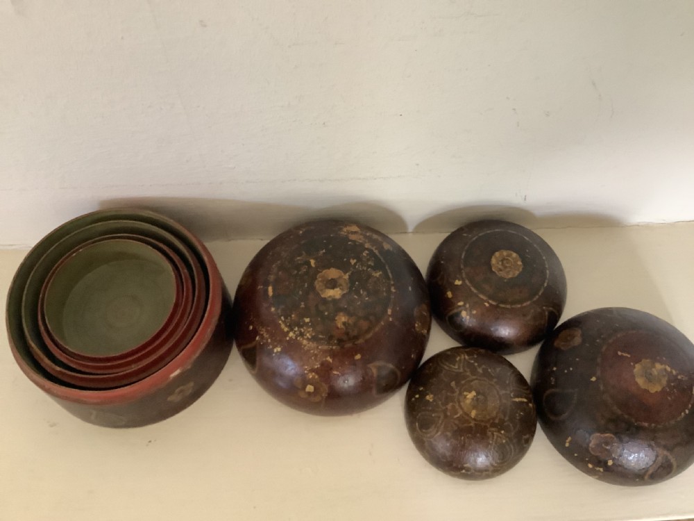 A set of four graduated round Kashmiri boxes painted in dark red and brown with gold floral and paisley motifs. View VIII