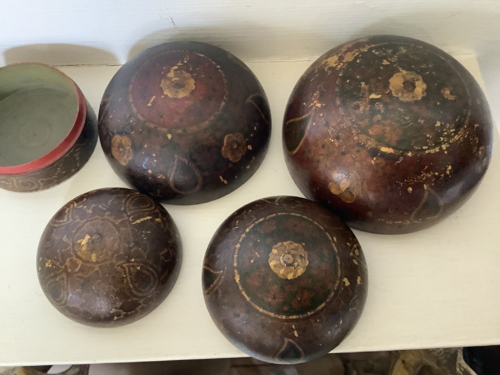 A set of four graduated round Kashmiri boxes painted in dark red and brown with gold floral and paisley motifs. View XII