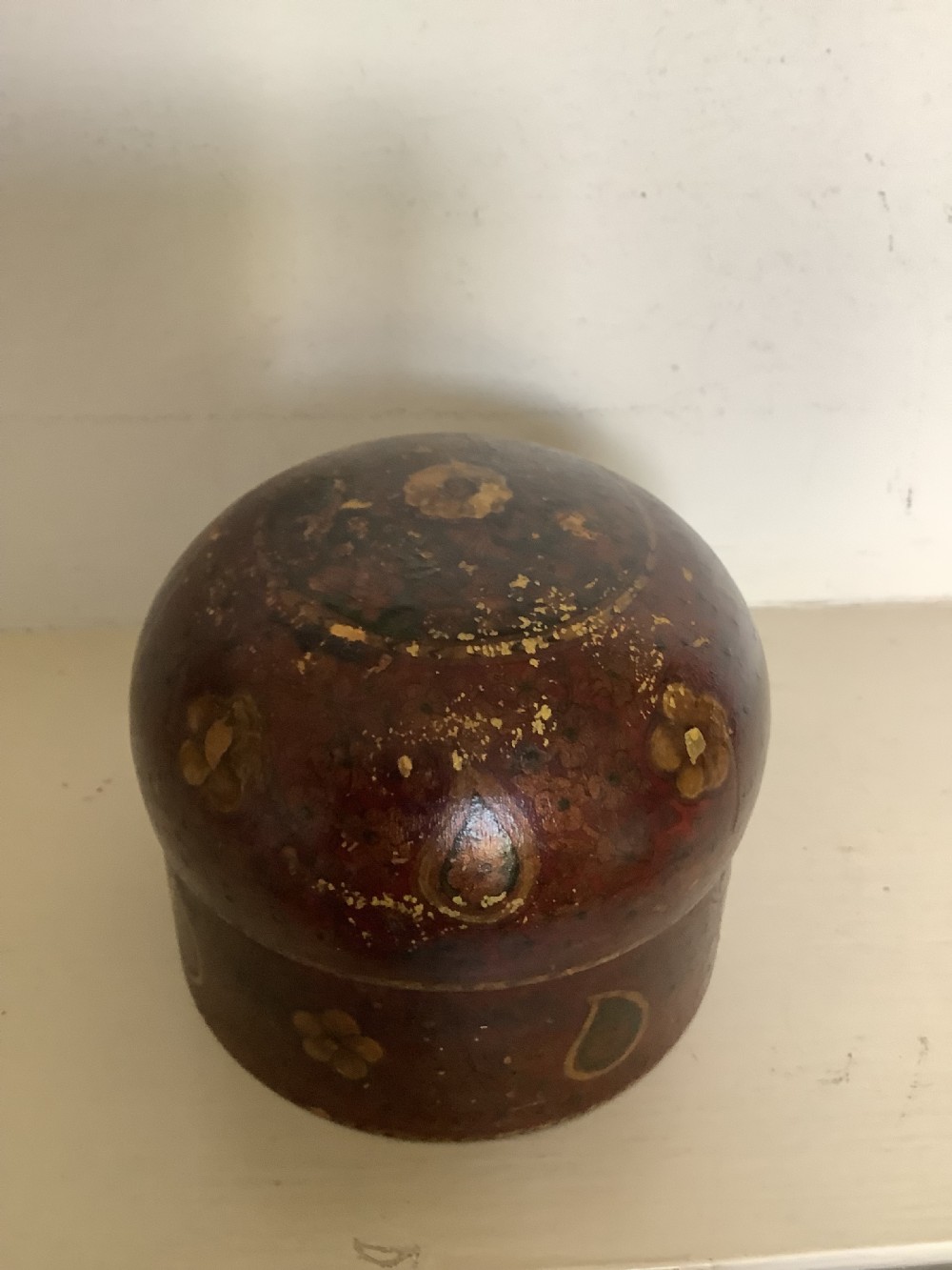 A set of four graduated round Kashmiri boxes painted in dark red and brown with gold floral and paisley motifs. View XIII
