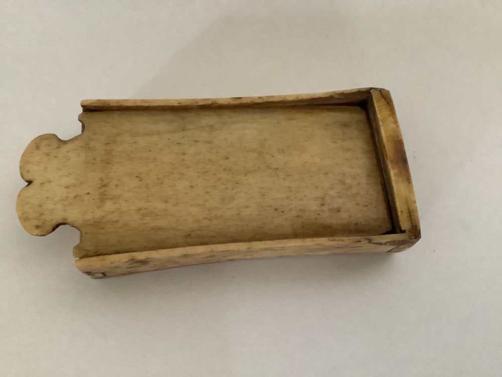 A hand-carved bone domino set featuring individual numbered tiles with incised dark pips next to a matching rectangular bone box with a sliding lid. View III