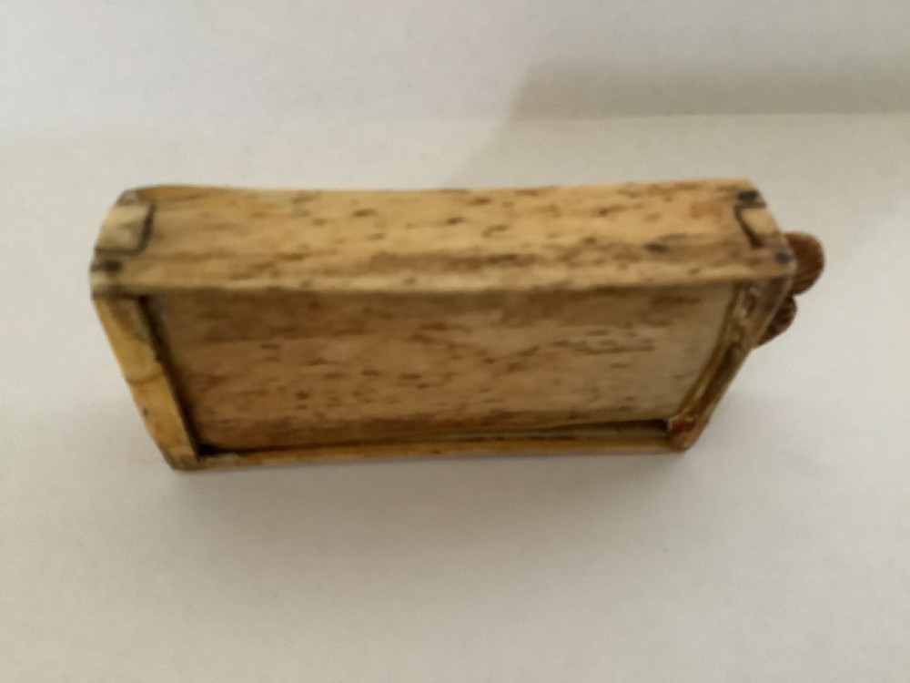 A hand-carved bone domino set featuring individual numbered tiles with incised dark pips next to a matching rectangular bone box with a sliding lid. View VIII