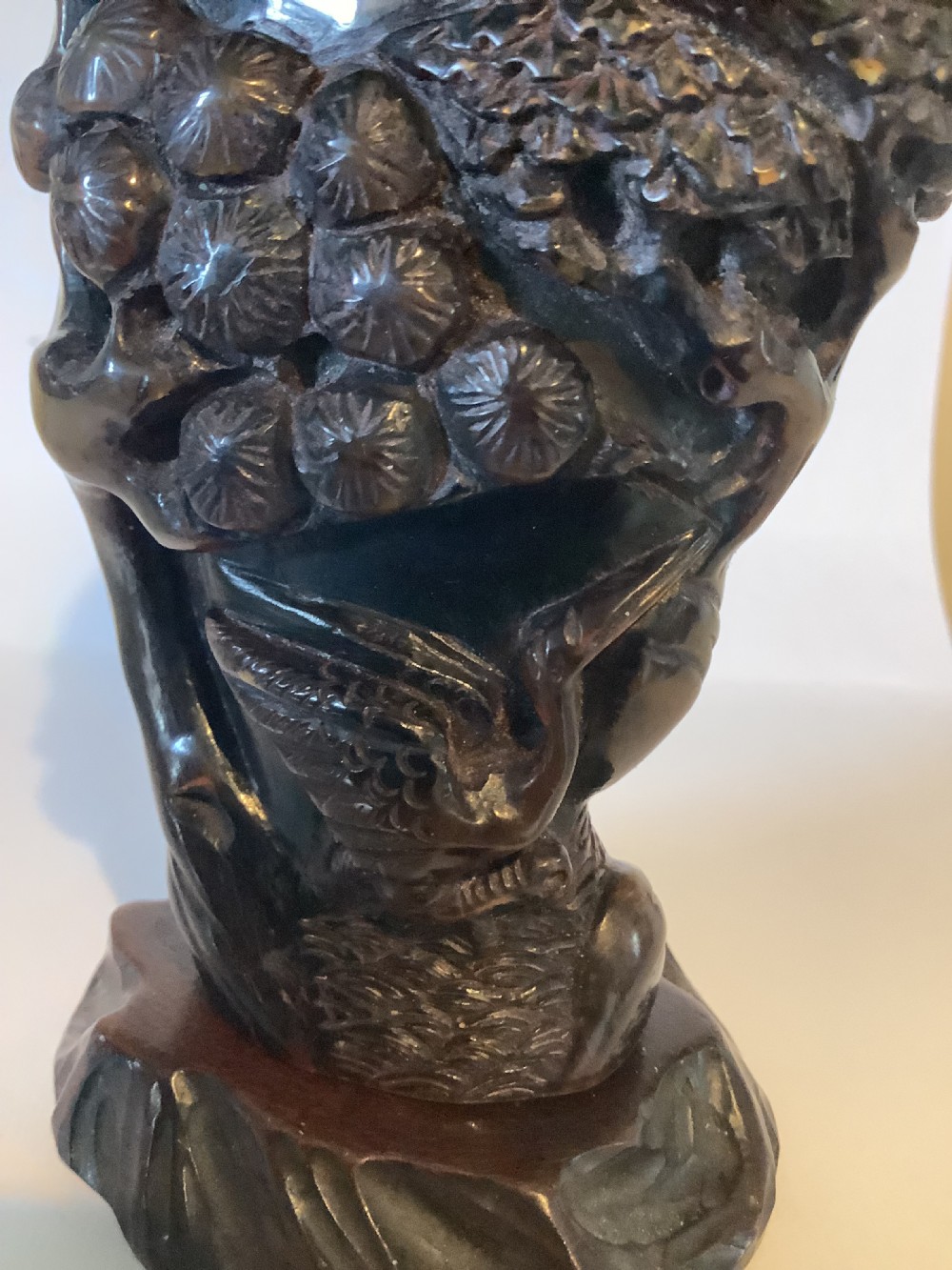 A deeply carved dark brown Chinese horn libation cup featuring intricate figural and floral relief details. View VII