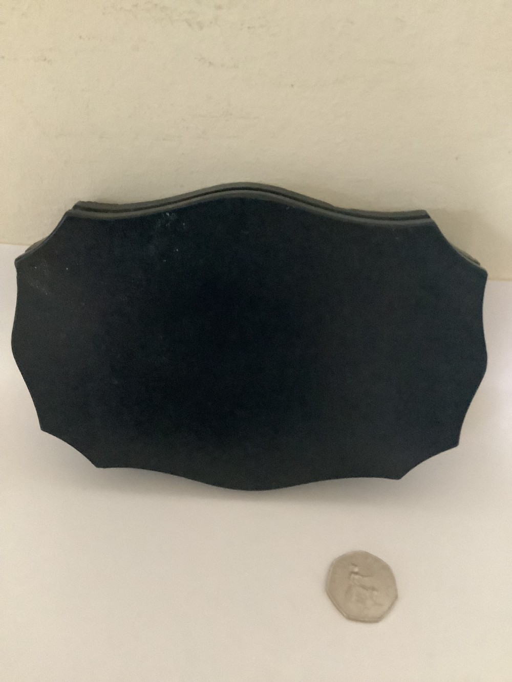 A shaped black marble plaque inlaid with five detailed micromosaic panels depicting classical Roman landmarks including Saint Peters Square and the Colosseum. View VI