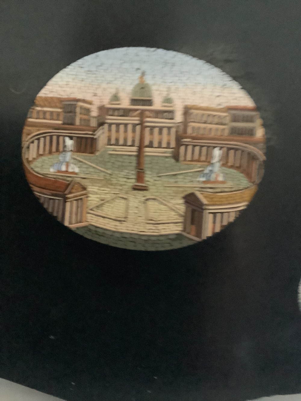 A shaped black marble plaque inlaid with five detailed micromosaic panels depicting classical Roman landmarks including Saint Peters Square and the Colosseum. View X