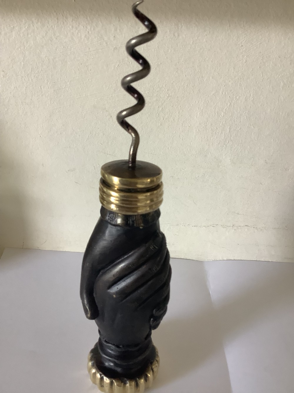 A cast brass and bronzed metal corkscrew featuring a handle formed in the shape of two clasped hands with a steel helix worm. View VIII