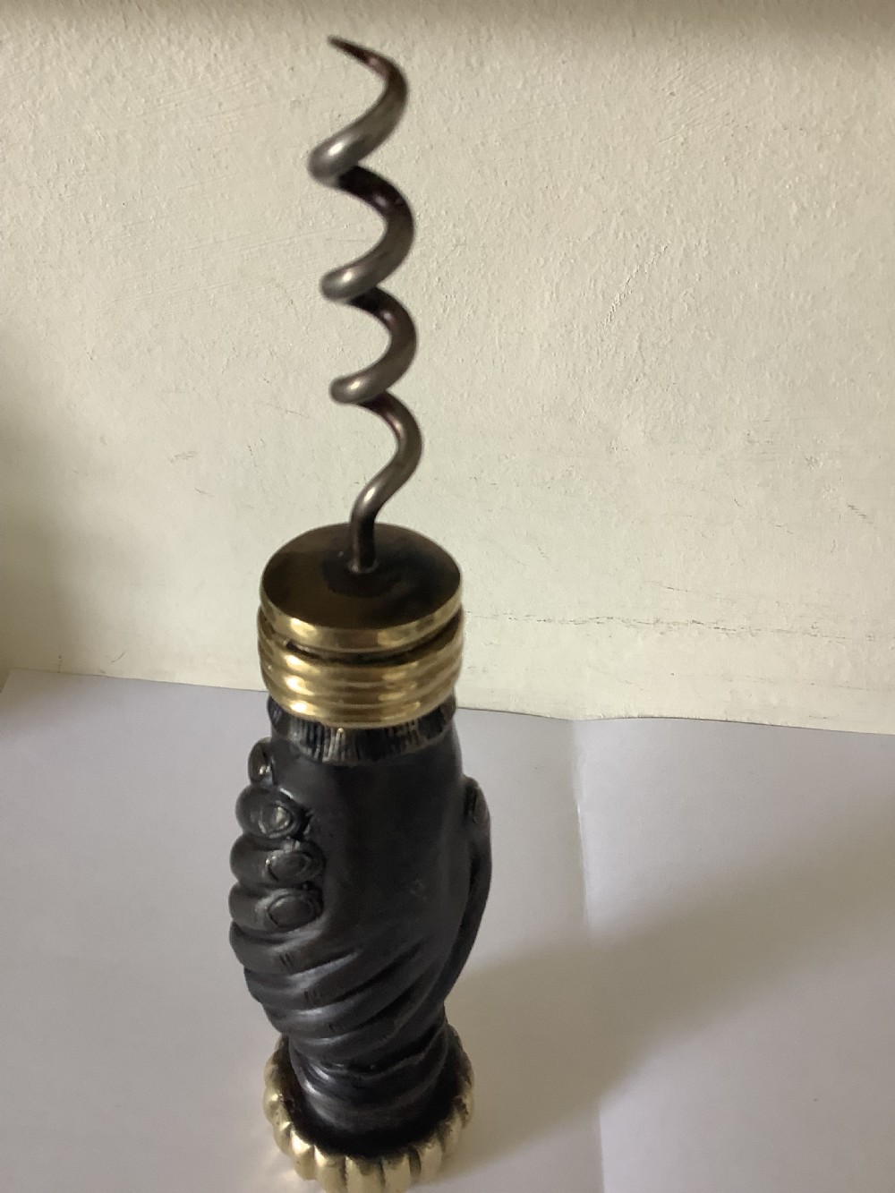 A cast brass and bronzed metal corkscrew featuring a handle formed in the shape of two clasped hands with a steel helix worm. View II