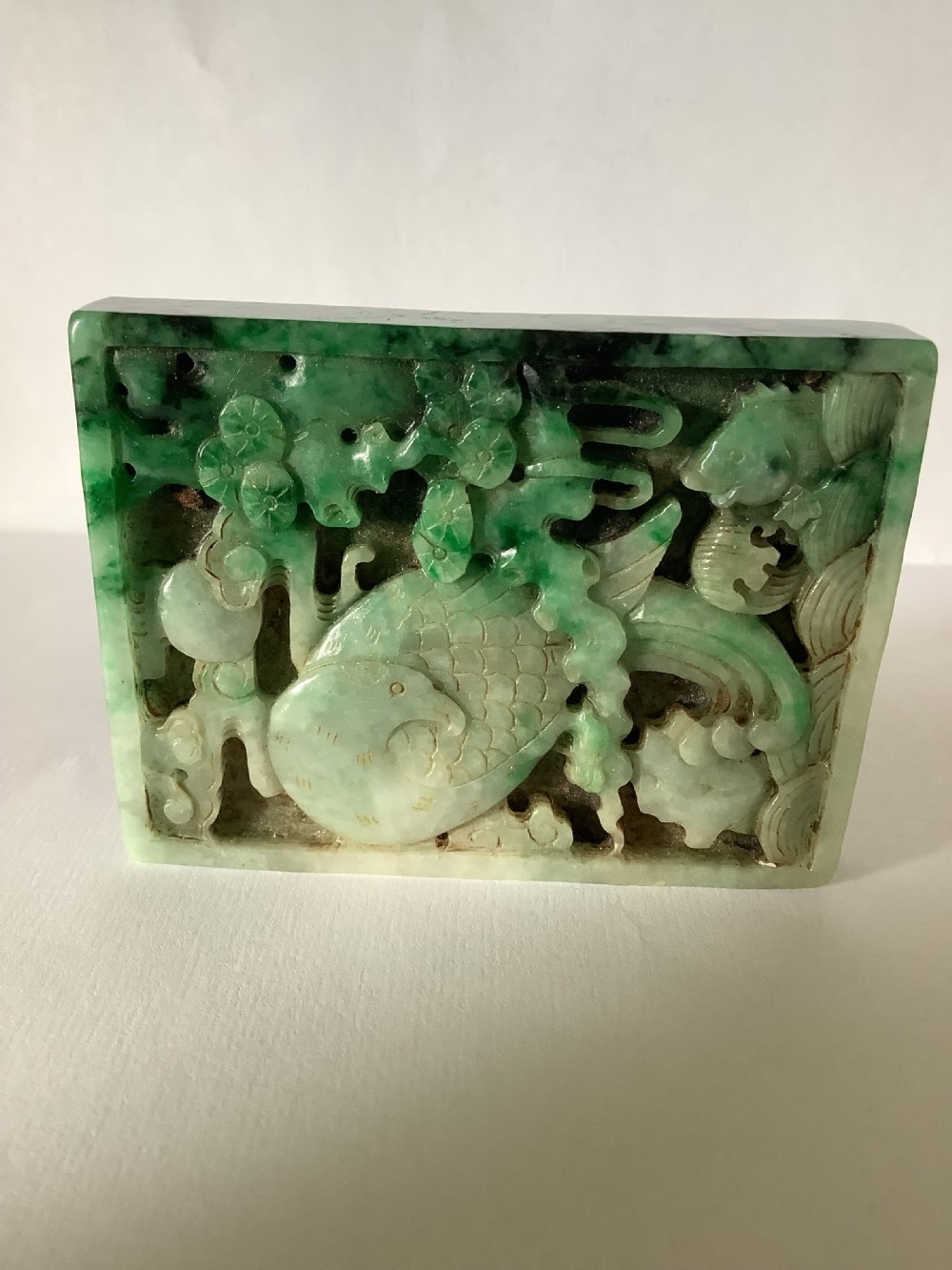 A rectangular openwork carved jade plaque featuring green and pale celadon tones with a carved bird and foliage motif. View IV