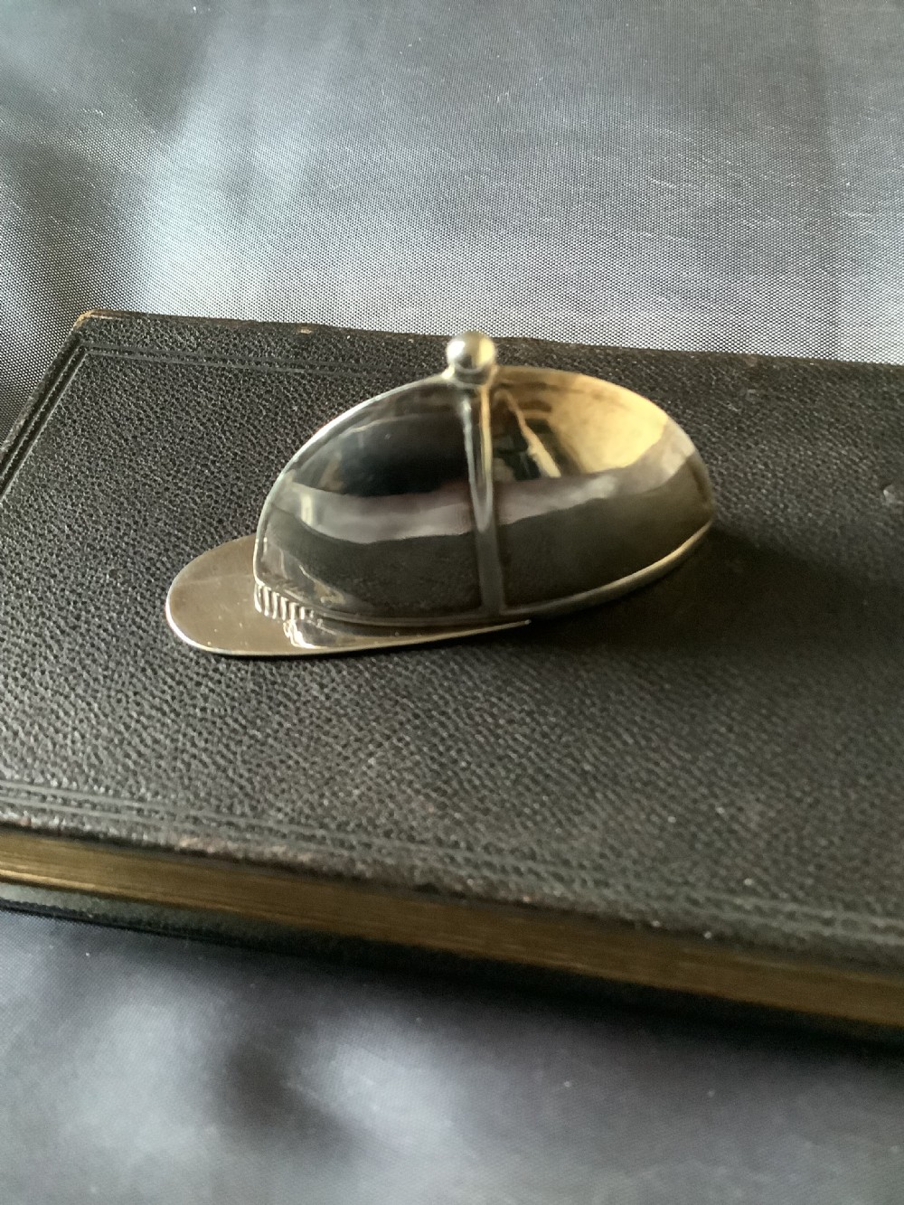 A sterling silver vesta case designed in the shape of an equestrian riding hat with a polished finish.