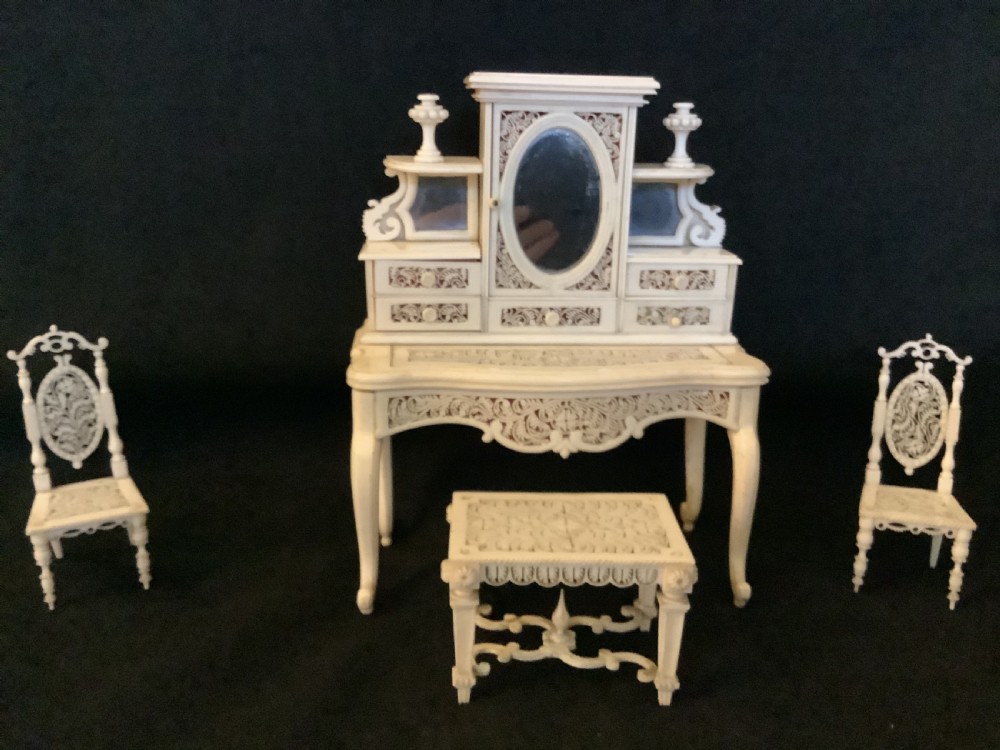 A miniature French carved bone boudoir suite featuring an ornate dressing table with mirror, a matching stool, and two side chairs with intricate pierced backs. View II