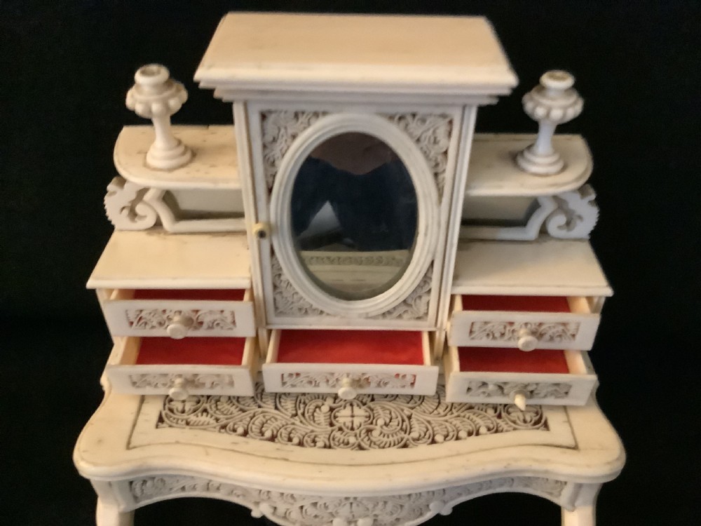A miniature French carved bone boudoir suite featuring an ornate dressing table with mirror, a matching stool, and two side chairs with intricate pierced backs. View IV