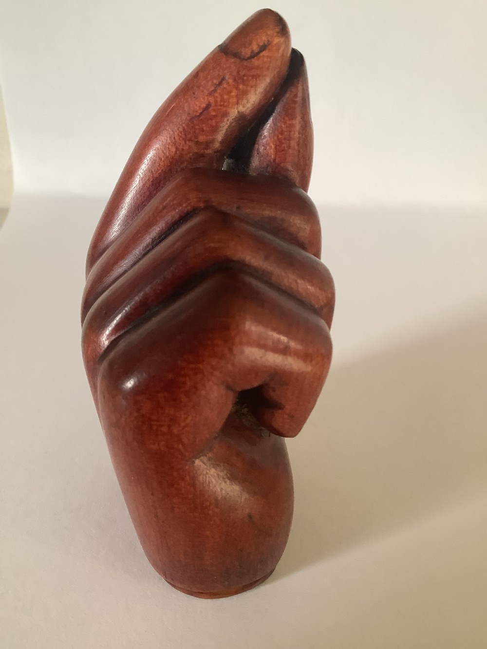 A nineteenth-century carved hardwood snuff box in the form of a hand holding a pinch of snuff, finished in a warm brown tone. View III