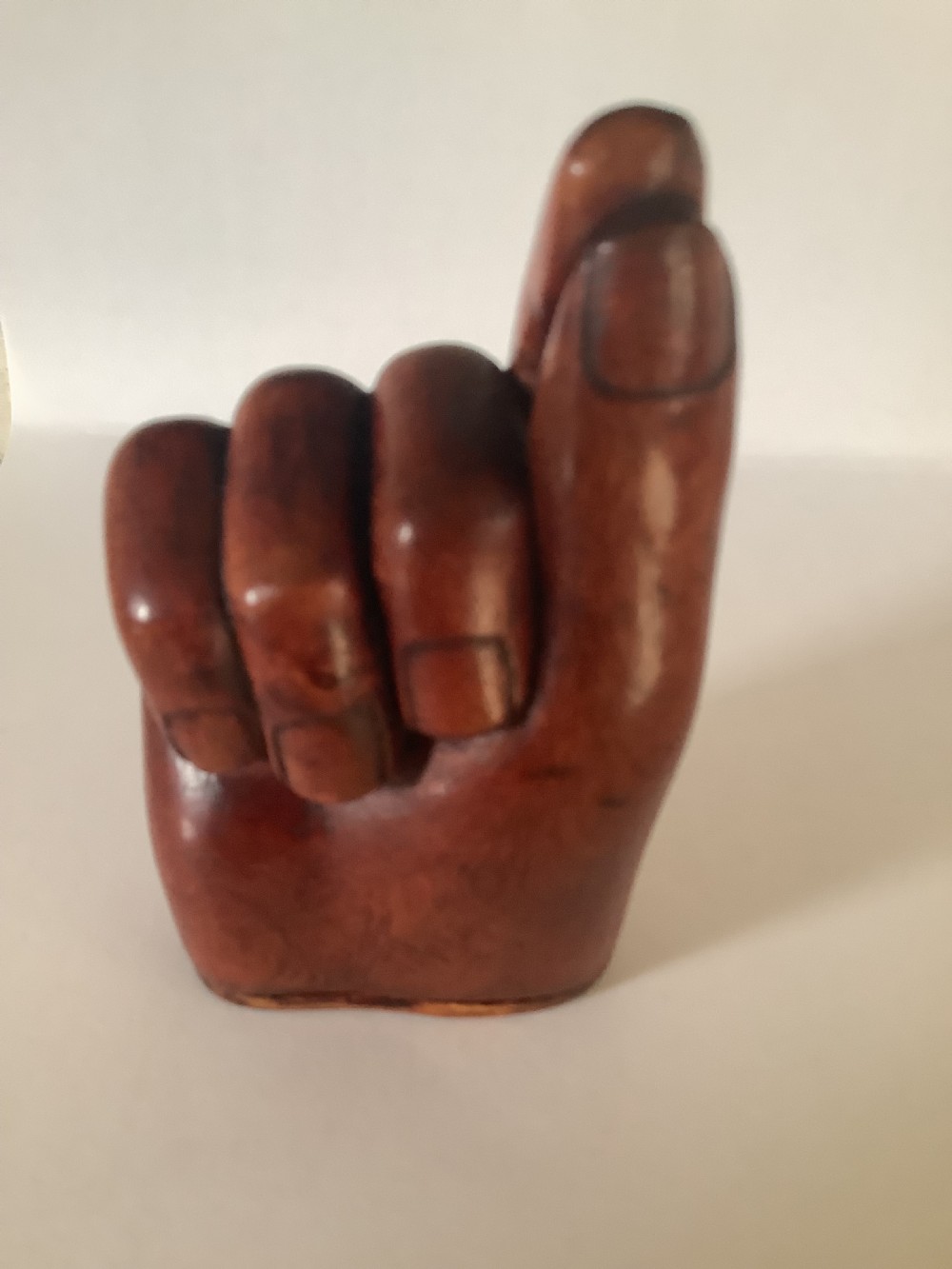 A nineteenth-century carved hardwood snuff box in the form of a hand holding a pinch of snuff, finished in a warm brown tone. View IV