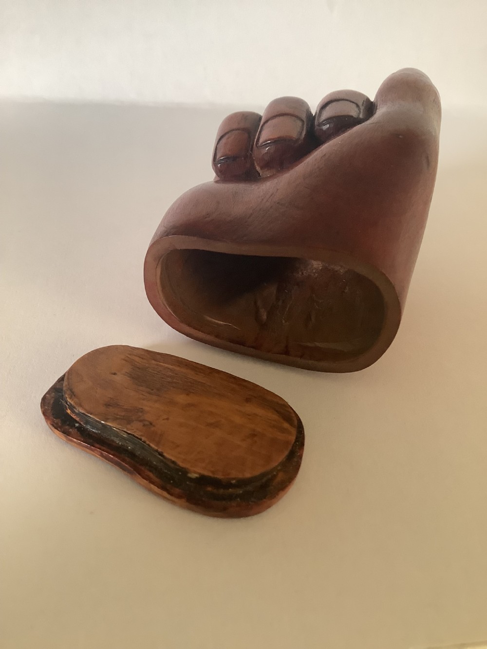 A nineteenth-century carved hardwood snuff box in the form of a hand holding a pinch of snuff, finished in a warm brown tone. View VI