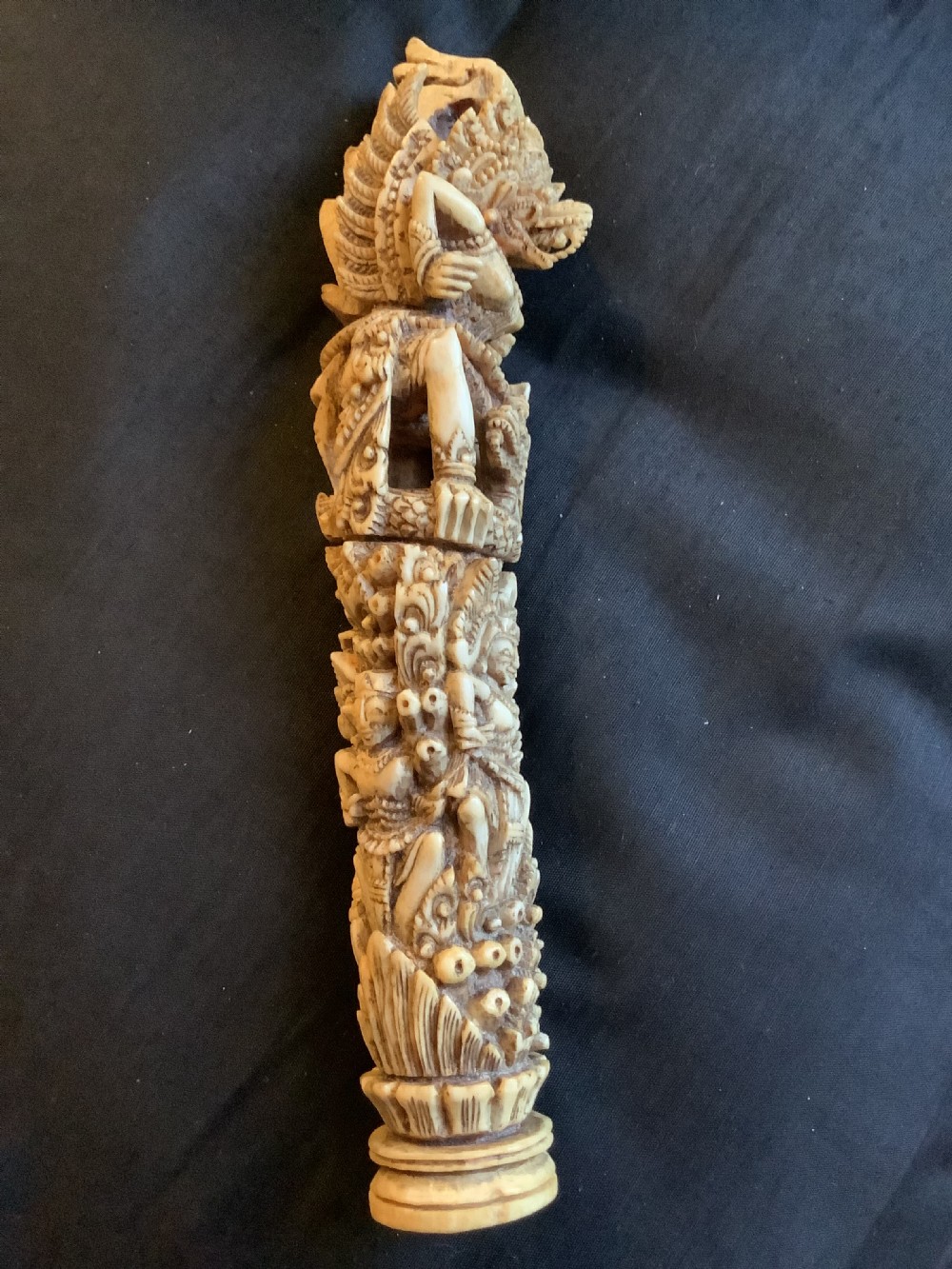 An intricately carved 19th-century sambar deer antler sword hilt featuring mythological figures and ornate traditional relief detailing.