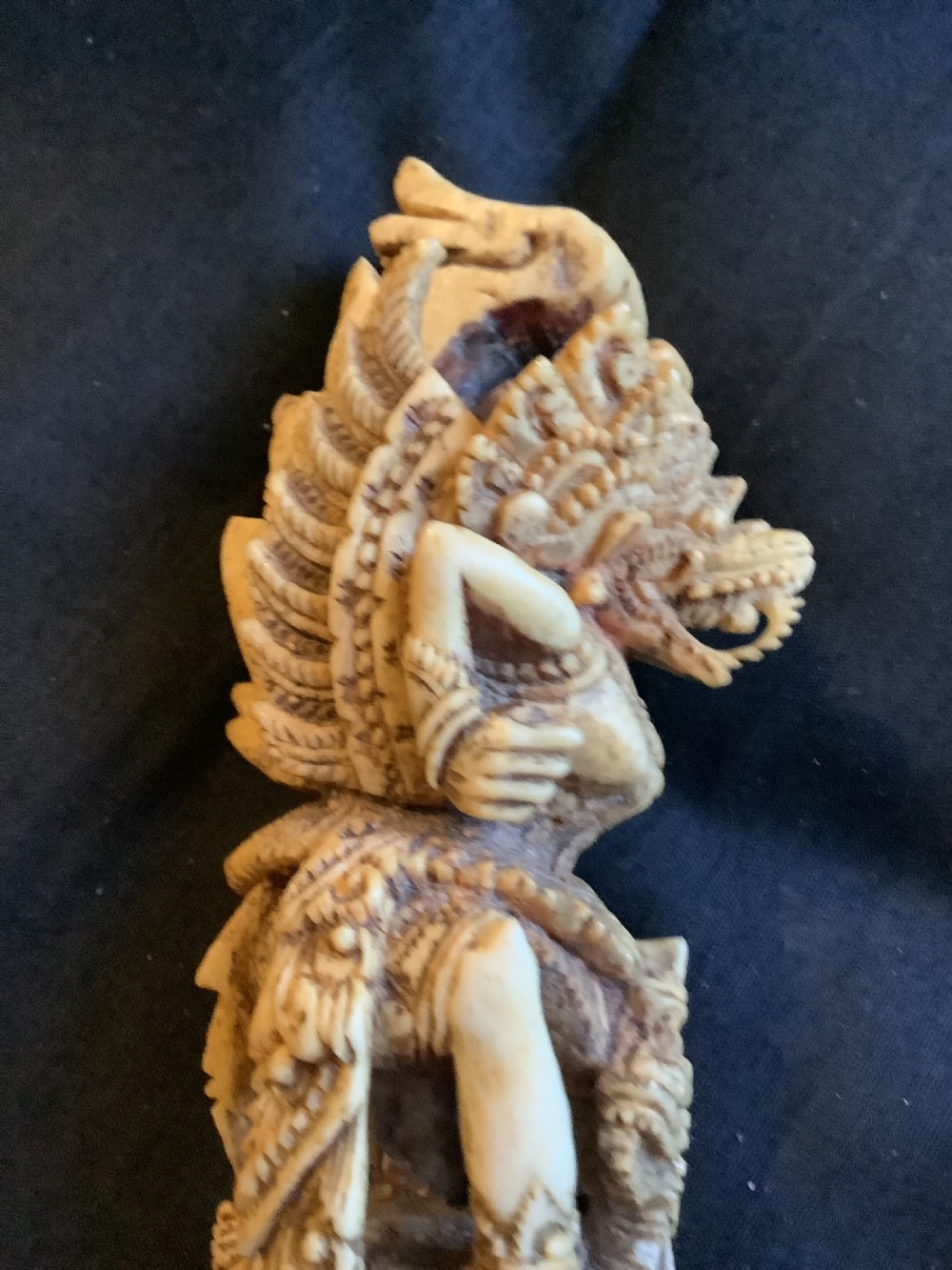 An intricately carved 19th-century sambar deer antler sword hilt featuring mythological figures and ornate traditional relief detailing. View III