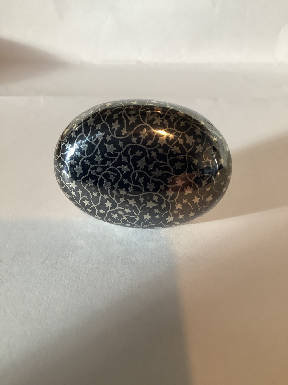 An oval silver-inlaid pocket snuff box featuring a foliage pattern and a central plain oval cartouche on the lid. View III