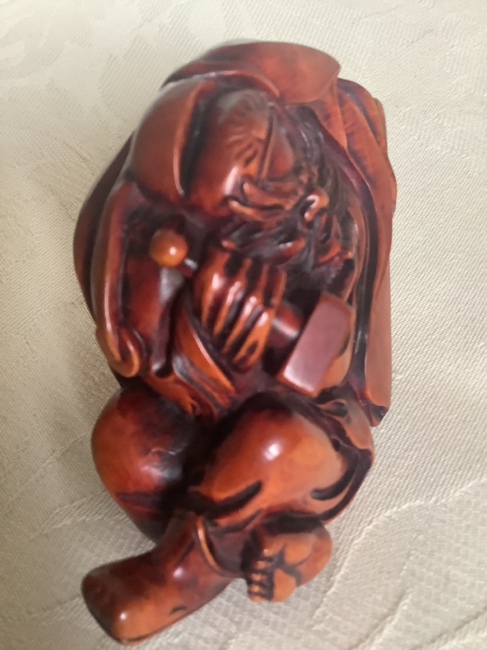 A Japanese hand-carved wooden figure depicting a bearded man in flowing robes with a smooth polished brown finish. View II