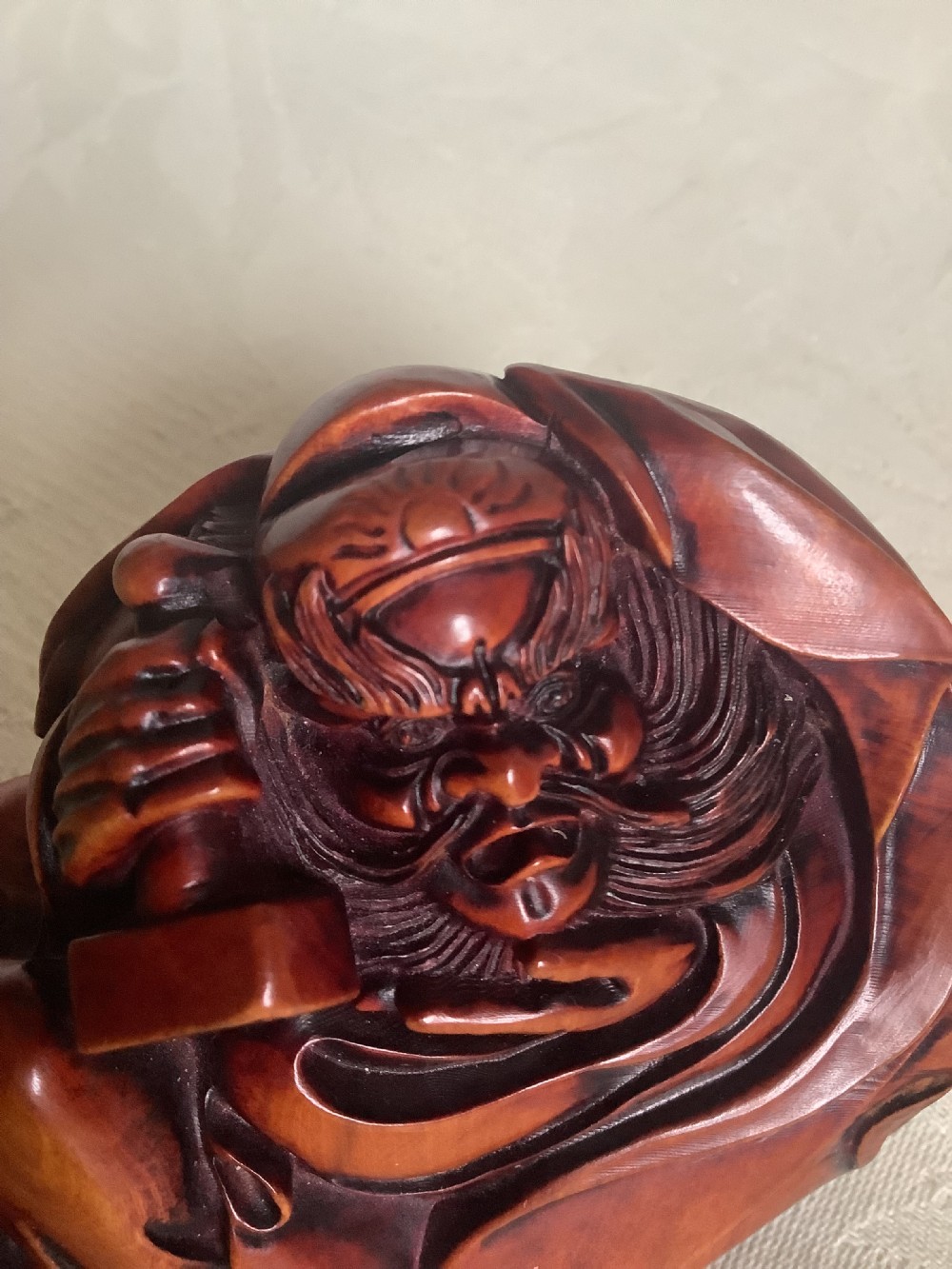 A Japanese hand-carved wooden figure depicting a bearded man in flowing robes with a smooth polished brown finish. View III